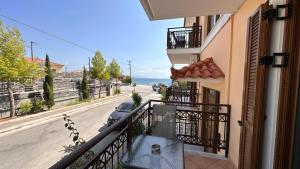 a balcony of a building with a bench on a street at Beach apartment next to the temple of Hera in Samos