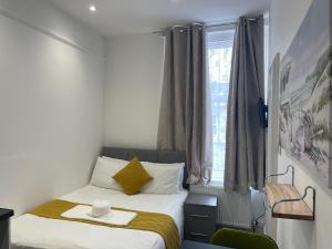 ein kleines Schlafzimmer mit einem Bett und einem Fenster in der Unterkunft Station House Plymouth in Plymouth