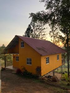 una pequeña casa amarilla con techo púrpura en CABAÑAS EL CHEPO en Chepo