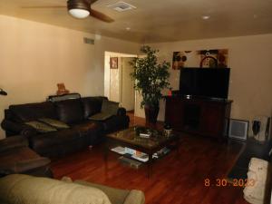 sala de estar con sofá y TV en Nice Northridge 4-2-2 Pool home near CSUN and Pierce College, en Northridge