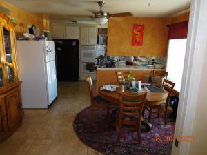a kitchen with a table and a white refrigerator at Nice Northridge 4-2-2 Pool home near CSUN and Pierce College in Northridge