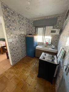 a small kitchen with a blue refrigerator and a sink at MARVIR en Alvorada in Barra del Chuy +4 photos