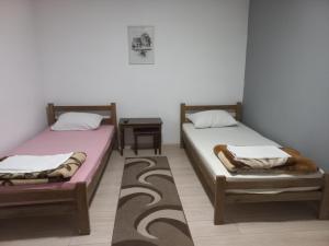 2 aparte bedden in een kamer met een tafel bij Apartmani Lovčević in Bogatić