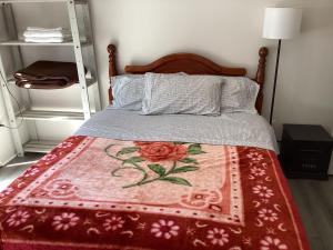 a bedroom with a bed with a red rug on it at Garden room B in West Vancouver
