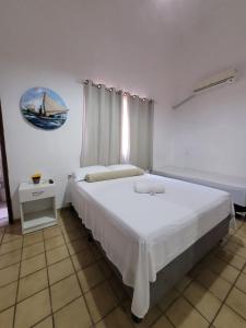 Un dormitorio con una gran cama blanca y una ventana en Pousada Águas Marinhas, en Maceió