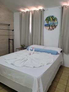 Un dormitorio con una cama blanca con un cisne. en Pousada Águas Marinhas, en Maceió