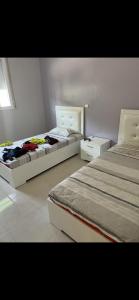 1 dormitorio con 2 camas y espejo en Maison vue mer Al Hoceïma en Alhucemas