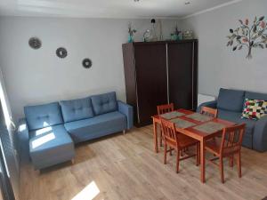 a living room with a blue couch and a table at Apartament na Kazimierza in Przemyśl
