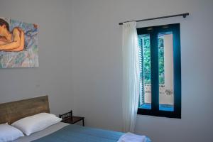 a bedroom with a bed and a window at Rias's Place in Kalamiós
