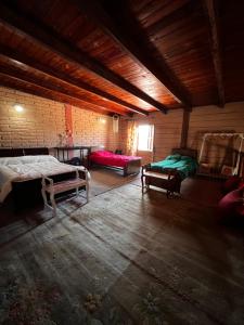 a room with two beds and two chairs in it at Cabaña Bethsabet Cafayate Salta in Cafayate