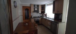 a small kitchen with a wooden table and a counter top at ECO-MANOLITA in Elche