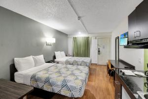 a hotel room with two beds and a kitchen at Studio 6-Bryan, TX - University Area in Bryan