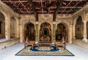 una stanza con due sedie e un tavolo in un edificio di Narayan Niwas Castle a Rāmgarh