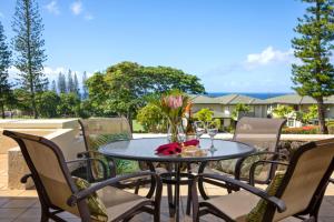 a table with a vase of flowers on a patio at K B M Resorts- KGV-25P6 Breathtaking 2Bd remodeled villa, ocean and golf fairway views in Kapalua