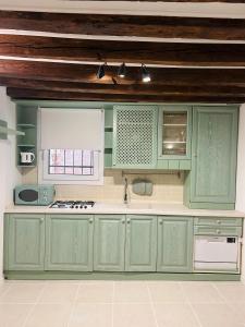 a kitchen with green cabinets and a window at Ca'Rosa in Venice
