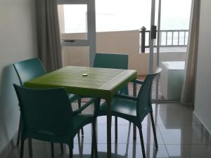 a dining room table with four chairs and a window at Beachfront - 34 Blue Largo in Westbrook