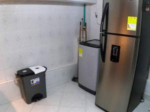a kitchen with a refrigerator and a trash can at Fresco Aparta estudio Envigado 101 in Envigado