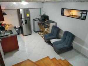 a living room with two chairs and a refrigerator at Fresco Aparta estudio Envigado 101 in Envigado