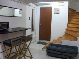 sala de estar con 2 sillas, barra y escaleras en Fresco Aparta estudio Envigado 101, en Envigado