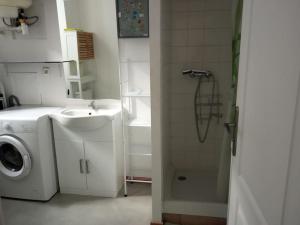 a bathroom with a washing machine and a sink at appartement Netflix parking gratuit climatisation in Saint-Ambroix