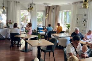 Rezydencja Pod Tężnią & SPA في إينوفروتسواف: مجموعة من الناس يجلسون على الطاولات في المطعم