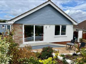 Churston FerrersにあるSeaspot is a 1 bed annex ground floor apartment at stunning Broadsands Beach nr Brixham!のパティオ(テーブル、窓付)が備わる家です。