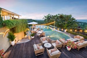 un patio al aire libre con piscina, mesas y sillas en Hidden Hills Villas - Small Luxury Hotels of The World, en Uluwatu