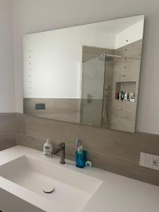 a bathroom sink with a large mirror above it at Seveso appartamento nuovo tra Milano, Monza e Como in Seveso