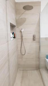 a shower with a shower head in a bathroom at Seveso appartamento nuovo tra Milano, Monza e Como in Seveso