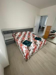 una camera con un letto e un piumone rosso e bianco di Seveso appartamento nuovo tra Milano, Monza e Como a Seveso