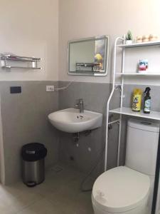 La salle de bains est pourvue d'un lavabo, de toilettes et d'un miroir. dans l'établissement Tropical Vacation Home Getaway, à San Juan