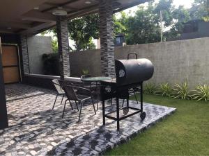 - un barbecue et des chaises sur la terrasse dans l'établissement Tropical Vacation Home Getaway, à San Juan