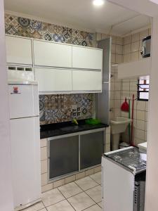 a kitchen with white cabinets and a sink at Apartamento lindo em Ubatuba - Centro in Ubatuba