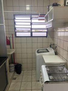 a small kitchen with a sink and a washing machine at Apartamento lindo em Ubatuba - Centro in Ubatuba +10 photos