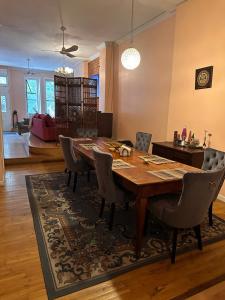 uma sala de jantar com uma mesa de madeira e cadeiras em Macaw Guest House em Nova York