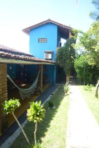 uma casa azul com uma rede em frente em Casa Franco Hospedaria em Trancoso