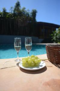 dois copos de vinho e um prato de uvas numa mesa em Casa Franco Hospedaria em Trancoso