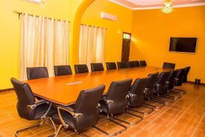 una gran sala de conferencias con una mesa larga y sillas en Tana Garden Hotel, en Garissa