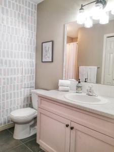 een badkamer met een wastafel, een toilet en een spiegel bij Bright 3 bed 3 bath House in Radium Hot Springs in Radium Hot Springs