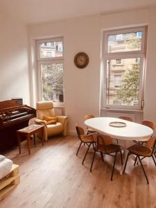 卡爾斯魯厄的住宿－Künstlerisches Apartment，客厅配有桌子和钢琴