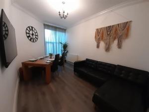 a living room with a couch and a table with chairs at Chic 5 double bedroom house - 15 min to Manchester in Manchester