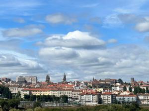 Blick auf eine Stadt mit Gebäuden und einem wolkigen Himmel in der Unterkunft Apartamento Lux Santiago in Santiago de Compostela