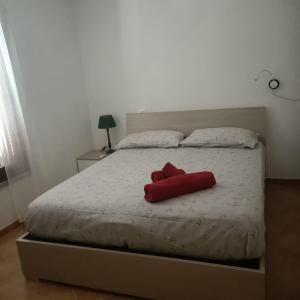 a red object is sitting on a bed at Santa Teresa Gallura Green House in Santa Teresa Gallura