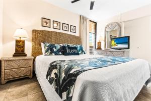 a bedroom with a large bed and a tv at Paki Maui 414 in Kahana +18 photos