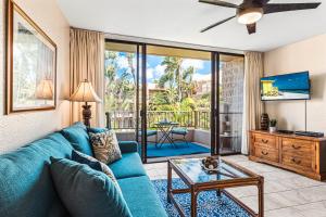 a living room with a blue couch and a table at Paki Maui 414 in Kahana