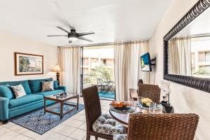 a living room with a blue couch and a table at Paki Maui 414 in Kahana