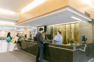 a group of people standing at a reception desk at Gage Suites at UBC in Vancouver