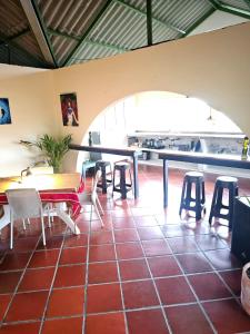 a restaurant with a table and stools in a room at Cabaña Mountain Ocean View Minca in Minca