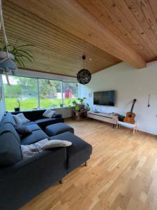 sala de estar con sofá azul y TV en Room W/hottub, sauna and firepit, en Seyðisfjörður