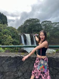 a woman standing in front of a waterfall at Wild Ginger Hotel in Hilo